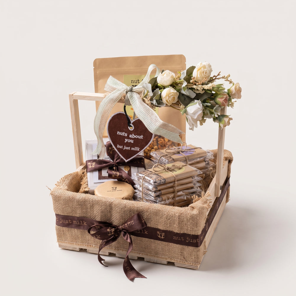 Nuts About You gift basket — jute-lined wooden crate with Nut Just Crunch snacks, ribbon, florals and a keychain